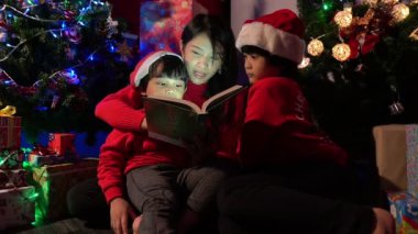 Noel ağacının yanında çocuklu mutlu bir anne, mutlu tatiller.