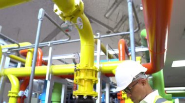 Büyük bir fabrikanın atık su yönetim sisteminde Asya Bakım Mühendisi, Tayland 'daki ısıtma sistemi ekipmanlarının teknik verilerini kontrol ediyor.