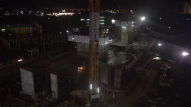 İnşaat halindeki bir binanın silüeti ve inşaat vinçleri. 