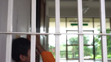 Demir hapishanede çaresiz Asyalı adam, mahkum konsepti.
