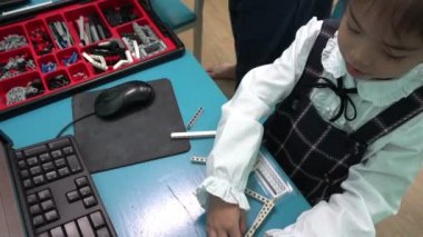 Asyalı küçük kız öğrenme saatleri, montaj robotu