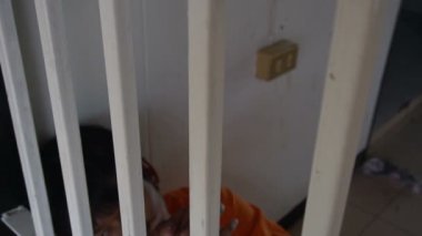 Demir hapishanede çaresiz Asyalı adam, mahkum konsepti.