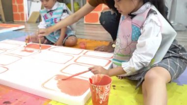 Genç Asyalı kızlar sanat okuyor, Taylandlı öğretmenlere resim yapıyor. 