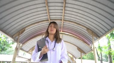 Dışarıda duran steteskoplu genç bayan doktor manzarası. 