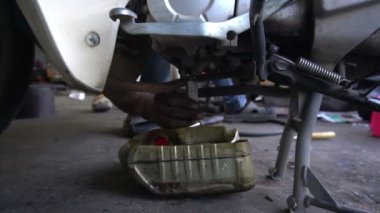 Motosiklet tamir eden adama yaklaş. 