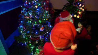 Noel ağacının yanında çocukları olan Noel Baba, iyi bayramlar.