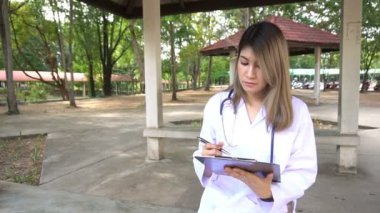 Dışarıda duran steteskoplu genç bayan doktor manzarası. 