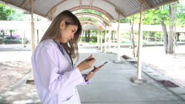 Dışarıda duran steteskoplu genç bayan doktor manzarası. 
