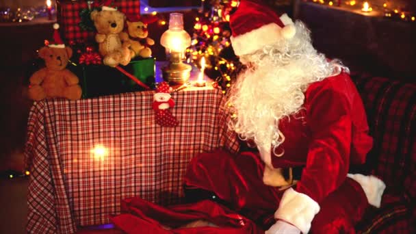 圣诞老人在圣诞树旁读书 带着花环和快乐假期的概念 — 图库视频影像
