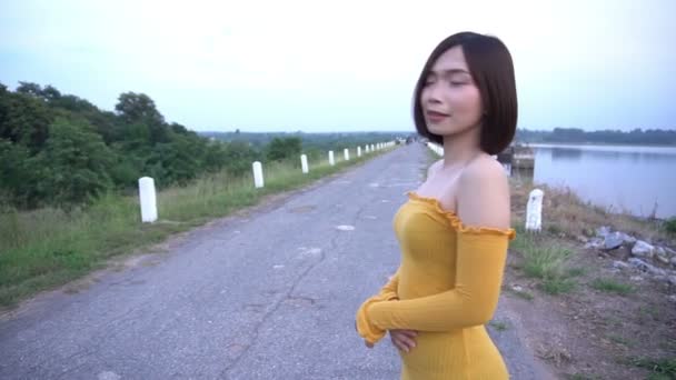 Vacker Asiatisk Kvinna Gul Klänning Poserar Utomhus — Stockvideo