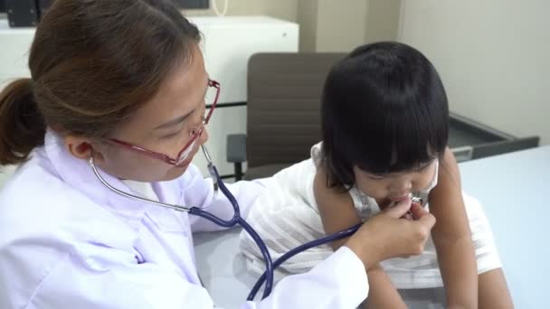 彼の呼吸と素敵な女の子の心をチェックするために聴診器を使用してアジアの医師 子供の健康をチェック タイの人々 — ストック動画
