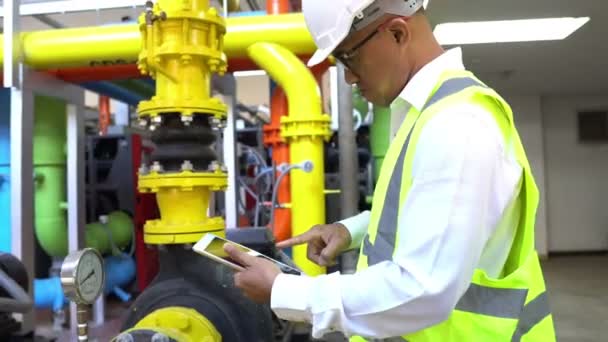 Asian Maintenance engineer at the waste water management system of a huge factory,maintenance checking technical data of heating system equipment,Thailand people — Stock Footage Asian Maintenance Engineer Waste Water Management System Huge Factory Maintenance Royalty Free Stock Video