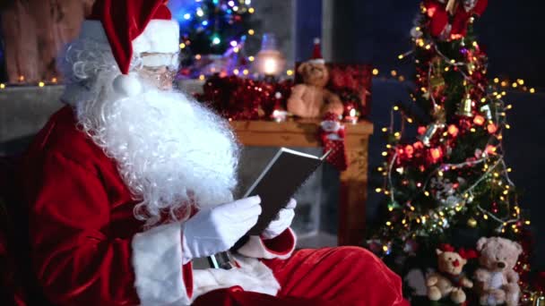 Weihnachtsmann Hält Notizbuch Bei Weihnachtsfeier Hause — Stockvideo