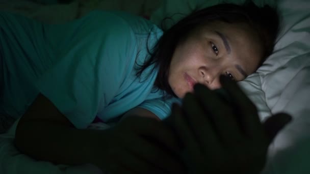 Asian Woman Playing Game Smartphone Bed Nighttime — Stock Video
