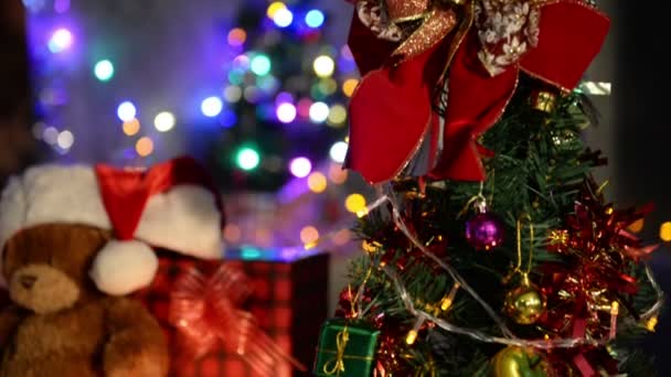 テディベア人形はクリスマスの背景のために飾るクリスマスの帽子を身に着けて — ストック動画
