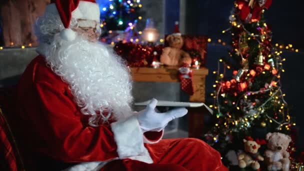 圣诞佳节期间 圣诞老人带着笔记本在家里 — 图库视频影像