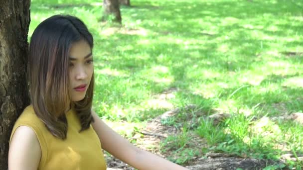 美丽的塔伊悲伤的女人白天呆在公园里 — 图库视频影像
