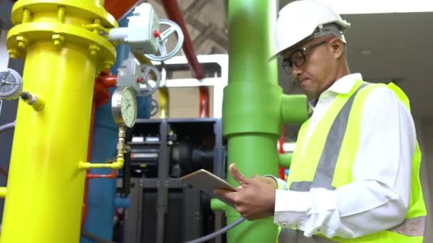 Asian Maintenance engineer at the waste water management system of a huge factory,maintenance checking technical data of heating system equipment,Thailand people — Stock Footage Asian Maintenance Engineer Waste Water Management System Huge Factory Maintenance Stock Footage