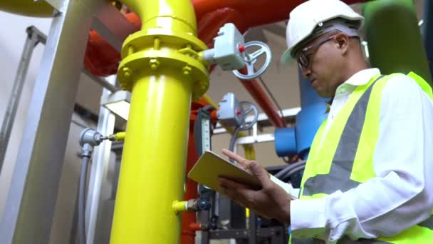 Asian Maintenance engineer at the waste water management system of a huge factory,maintenance checking technical data of heating system equipment,Thailand people — Stock Footage Asian Maintenance Engineer Waste Water Management System Huge Factory Maintenance Stock Footage