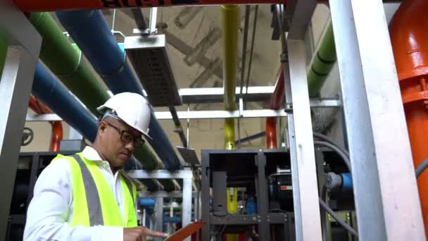공장의 시스템에서 일하는 아시아인 기술자 시스템 장비의 기술적 데이터를 확인하는 — 비디오