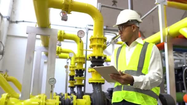 Asian Maintenance engineer at the waste water management system of a huge factory,maintenance checking technical data of heating system equipment,Thailand people — Stock Footage Asian Maintenance Engineer Waste Water Management System Huge Factory Maintenance Stock Footage