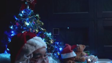 Noel Baba, Noel ağacının yanında çelenkli mektup okuyor. Mutlu tatiller.