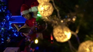 Noel Baba Noel ağacının yanında çelenk okuyan çocuk, mutlu bayramlar.