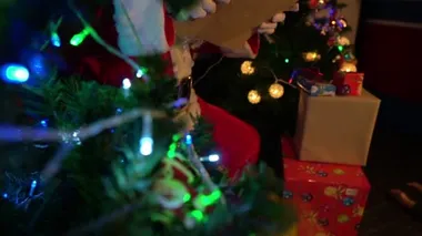 Noel Baba, Noel ağacının yanında çelenkli mektup okuyor. Mutlu tatiller.
