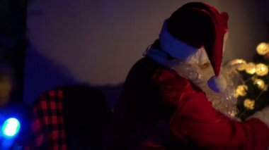 Noel Baba 'nın Noel ağacını çelenkle süslemesi, mutlu bayramlar.