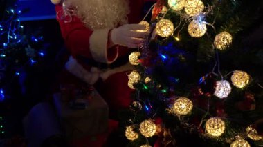 Noel Baba 'nın Noel ağacını çelenkle süslemesi, mutlu bayramlar.