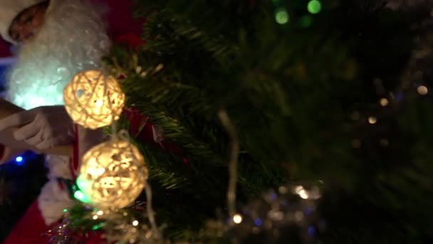 サンタクロースはガーランドでクリスマスツリーを飾る 幸せな休日のコンセプト — ストック動画