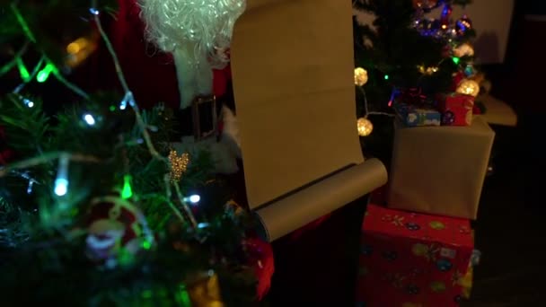 サンタはガーランドとクリスマスツリーの近くに手紙を読んで 幸せな休日のコンセプト — ストック動画