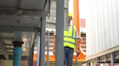 Asyalı mühendis bakımı ısıtma sistemi ekipmanlarının teknik verilerini kontrol ediyor
