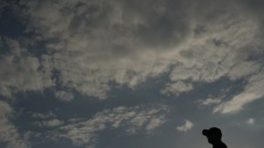 Güzel günbatımında golf oynayan Asyalı golfçünün silueti