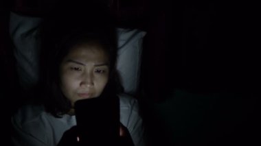 Asyalı kadın gece yatakta akıllı telefon çalar, Taylandlılar...