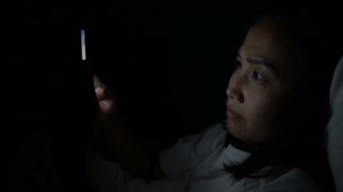 Asyalı kadın gece yatakta akıllı telefon çalar, Taylandlılar...