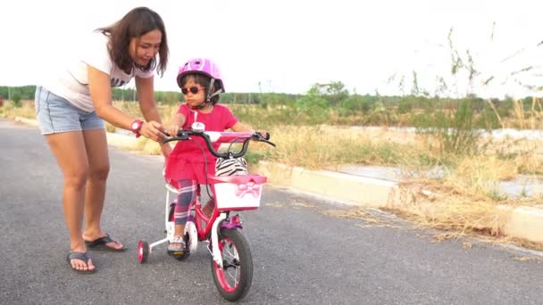 Mother Helping Little Daughter Helmet Riding Bicycle Outdoors — Stock Video