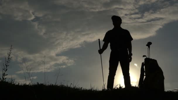 美丽的落日下 亚洲高尔夫球手打高尔夫的轮廓 — 图库视频影像