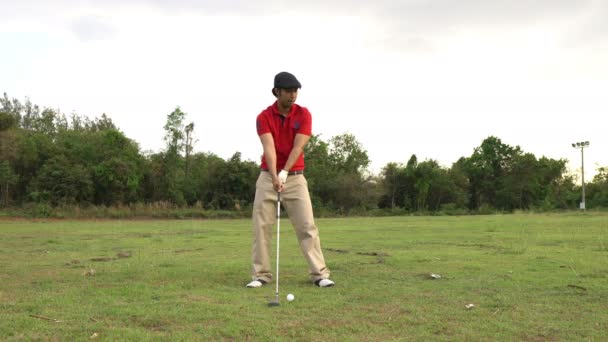 asiatischer Golfer beim Golfen bei strahlendem Sommertag, Sportkonzept