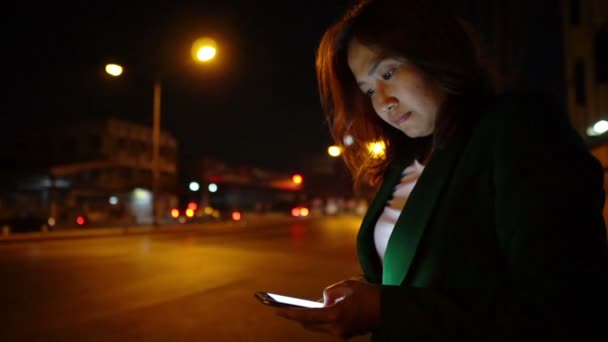 Asian Woman Using Smartphone While Standing Road Side Nighttime — Stock Video