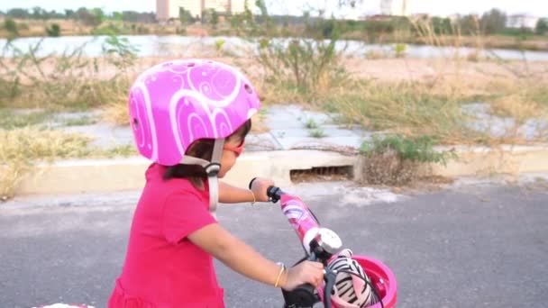 可愛いですアジアの女の子でヘルメット乗馬自転車屋外 — ストック動画