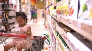 Anne ve tatlı kız süpermarkette ürün seçiyorlar. 