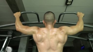 Büyük kaslı Asyalı adam spor salonunda ağırlık çalışması yapıyor.