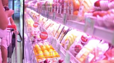 Anne ve tatlı kız süpermarkette ürün seçiyorlar. 