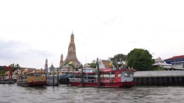 Nehirden geçen feribot, Bangkok, Tayland 'daki Şafak Tapınağı Wat Arun' a doğru gidiyor.