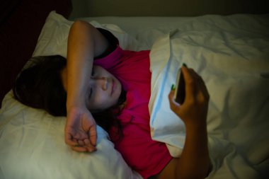 Asyalı kadın gece yatakta akıllı telefonla oyun oynuyor, Taylandlılar, sosyal medya bağımlısı.