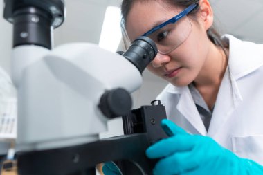 Laboratuvarda çalışan Asyalı bilim adamı araştırmacılar deneyin sonuçlarını araştırıyorlar.