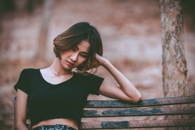 Asyalı güzel kız ormanda kendini yalnız hissediyor, üzgün kadın konsepti.