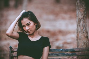 Asyalı güzel kız ormanda kendini yalnız hissediyor, üzgün kadın konsepti.