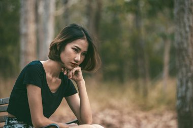 Asyalı güzel kız ormanda kendini yalnız hissediyor, üzgün kadın konsepti.